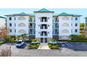 Exterior view of condo building featuring neutral paint, multiple balconies, and assigned parking spots at 9203 Griggs Rd # B102, Englewood, FL 34224