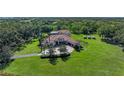 Sprawling estate featuring a circular driveway, luxurious home, solar panels, and manicured lawns at 1110 79Th E St, Palmetto, FL 34221
