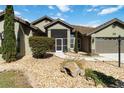 This home features a well-manicured lawn, rock landscaping, and a two-car garage at 1118 Deardon Dr, Venice, FL 34292
