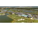 An aerial view showcasing a resort-style pool, golf course, lakes, and picturesque neighborhood at 15916 Sugar Hill Dr, Punta Gorda, FL 33982