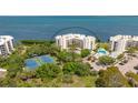 Aerial view of waterfront condominium complex with tennis courts and pool at 2020 Harbourside Dr # 454, Longboat Key, FL 34228