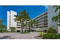 Exterior shot of the condo building with a brick driveway and lush landscaping at 2020 Harbourside Dr # 454, Longboat Key, FL 34228