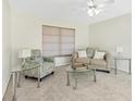 Cozy living room featuring a sofa, chair, and glass tables with carpet floors and a ceiling fan at 206 Elliot Ave # 137, Sarasota, FL 34232