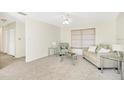Bright living room featuring neutral walls, plush carpet, and comfortable seating near a window with blinds at 206 Elliot Ave # 137, Sarasota, FL 34232
