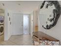 Foyer with tile flooring, seashell table, decorative mirror, washer, and dryer at 2675 Gulf Of Mexico Dr # 403, Longboat Key, FL 34228