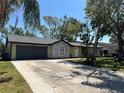 Charming single-story home with a two-car garage and a wide driveway, shaded by palm trees at 2816 N Lockwood Meadows Blvd, Sarasota, FL 34234