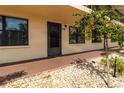 Condo entrance showcasing a welcoming walkway with decorative stone landscaping and a small tree at 305 30Th Ave W # A104, Bradenton, FL 34205