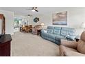 Open-concept living and dining area with neutral carpet and ceiling fans at 305 30Th Ave W # A104, Bradenton, FL 34205
