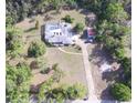 Aerial view of home with pool, fenced-in backyard, long driveway, and surrounded by lush trees at 3052 51St St, Sarasota, FL 34234