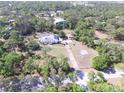 Overhead view of home with long driveway, in-ground pool, and surrounded by mature trees at 3052 51St St, Sarasota, FL 34234
