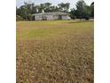 View of one-story ranch style home and expansive grass lawn with mature trees at 3052 51St St, Sarasota, FL 34234
