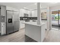 Modern kitchen featuring white cabinets, stainless steel appliances, and a stylish black backsplash at 3333 Ramblewood Pl, Sarasota, FL 34237