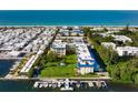 Stunning aerial view of the beachfront condo with boat docks and lush landscaping at 3802 Gulf Of Mexico Dr # A103, Longboat Key, FL 34228