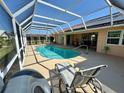 Beautiful in-ground swimming pool with a screened enclosure and a patio with furniture at 417 Firethorn Ave, Englewood, FL 34223