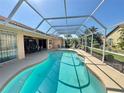 Gorgeous in-ground pool inside a screened enclosure, surrounded by lush landscaping and perfect for relaxation at 417 Firethorn Ave, Englewood, FL 34223