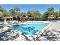 Community pool surrounded by lounge chairs and tropical palm trees, perfect for relaxation at 4375 Trails Dr # 17-1, Sarasota, FL 34232