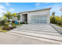 Modern home featuring a sleek glass garage door, well manicured landscaping, and a unique driveway at 600 De Narvaez Dr, Longboat Key, FL 34228
