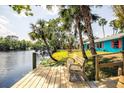 Relax on the waterfront deck with views of the property, palm trees, and serene river at 6737 Lincoln Rd, Bradenton, FL 34203