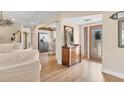 Inviting foyer featuring hardwood floors, decorative mirror, and entry to kitchen and living areas at 6820 19Th W Ave, Bradenton, FL 34209