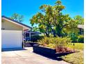 A lovely one-story home featuring an attached garage and beautifully landscaped front yard with mature trees at 7314 Mauna Loa Blvd, Sarasota, FL 34241