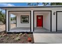 Inviting front porch features a bright red door, black trim, and fresh landscaping at 732 15Th E St, Bradenton, FL 34208
