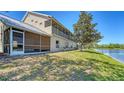A lush backyard featuring a screened-in patio, a view of a serene pond, and green lawn at 7687 Sweetbay Cir # 7687, Bradenton, FL 34203