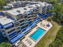 Beautiful condo complex with a sparkling pool, lounge chairs, and sunny blue awnings at 835 S Osprey Ave # 415, Sarasota, FL 34236