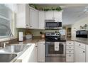 Well-lit kitchen featuring stainless steel appliances, white cabinets, and ample countertop space at 8402 Princess Ct, Palmetto, FL 34221