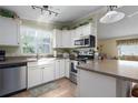 Bright kitchen with white cabinetry, stainless steel appliances, and a convenient island counter at 8402 Princess Ct, Palmetto, FL 34221