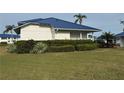 Attractive home exterior featuring a well-manicured lawn, vibrant green bushes, and a blue metal roof at 859 Audubon Dr # 859, Bradenton, FL 34209