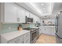 Bright kitchen with white cabinets, stainless steel appliances, and a tile backsplash at 8735 Midnight Pass Rd # 306B, Sarasota, FL 34242