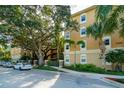 The exterior of the home features a tan stucco facade complemented by lush trees and landscaping at 1268 11Th St # 2402, Sarasota, FL 34236