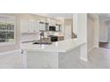 Bright, all-white kitchen with marble countertops and tiled floor at 13 Bayhead Ln, Osprey, FL 34229