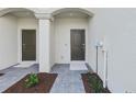 Close-up of townhome entrances with dark doors, grey paver walkway, and neutral paint at 14783 Lyla Ter, Bradenton, FL 34211