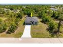Areal view of home in a wooded area with a long concrete driveway leading to the front door at 158 Chickering St, Port Charlotte, FL 33954