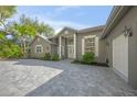 Stately gray home with meticulously maintained landscaping and an expansive paver driveway at 1693 Landings Ln, Sarasota, FL 34231