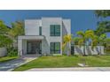 A contemporary two-story home features clean lines, modern windows, and a well-manicured lawn at 1755 7Th St, Sarasota, FL 34236
