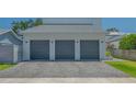 A three-car garage with gray doors and a paver driveway offers ample parking space at 1755 7Th St, Sarasota, FL 34236