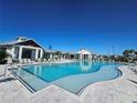 Resort-style community pool with sun loungers, clear blue water, and nearby cabana, perfect for relaxation at 17676 Savory Mist Cir, Bradenton, FL 34211
