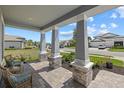 Inviting covered front porch with stone pillars, wicker chairs, and beautiful community views at 17676 Savory Mist Cir, Bradenton, FL 34211