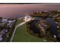 Aerial view showcases the waterfront property, lush landscaping, and boat dock in a tranquil setting at 327 Riverpoint Ne Dr, Bradenton, FL 34208