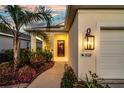 Close-up view of the front entrance, featuring a well-lit porch and decorative landscaping at 3520 Woodmont Dr, Parrish, FL 34219
