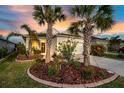 Inviting home featuring a well-manicured lawn, mature palm trees, and vibrant landscaping at 3520 Woodmont Dr, Parrish, FL 34219
