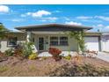Inviting exterior with lush landscaping, covered entrance, and attached one-car garage at 3828 20Th N St, St Petersburg, FL 33714