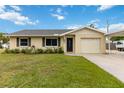 Inviting single-story home with a manicured lawn, attached garage, and a cozy, welcoming facade at 4221 3Rd W Ave, Palmetto, FL 34221