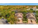 Aerial view of neighborhood homes with serene pond, mature landscaping and wooded area at 4344 Nizza Ct, Venice, FL 34293