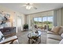 Inviting living room with modern decor, neutral tones, and a view of the golf course through sliding glass doors at 4440 Fairways Blvd # 210, Bradenton, FL 34209