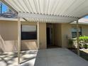 Close-up of a tan house with a carport, highlighting its welcoming entrance at 4944 Village Gardens Dr # 151, Sarasota, FL 34234