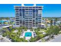 Exterior image of a modern condo building with a beautiful pool and palm trees at 5300 Ocean Blvd # 202, Sarasota, FL 34242