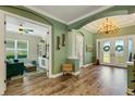 Spacious foyer showcases hardwood floors, a decorative chandelier, and inviting green-painted walls and trim at 5329 Trails Bend Ct, Sarasota, FL 34238